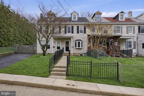 a front view of a house with a garden and plants