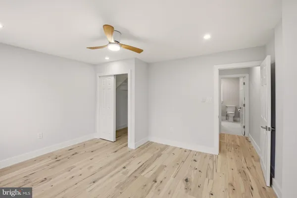 a view of a room with wooden floor and ceiling fan