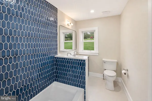 a bathroom with a toilet a sink and a window