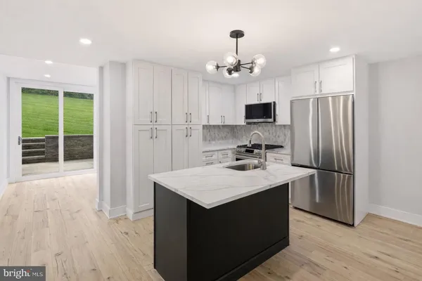 a kitchen with kitchen island a sink stainless steel appliances and view kitchen
