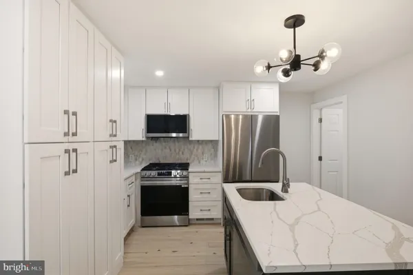 a kitchen with stainless steel appliances granite countertop a refrigerator a stove a sink and a refrigerator