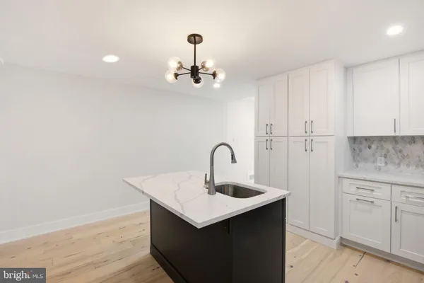 a kitchen with a sink cabinets and wooden floor