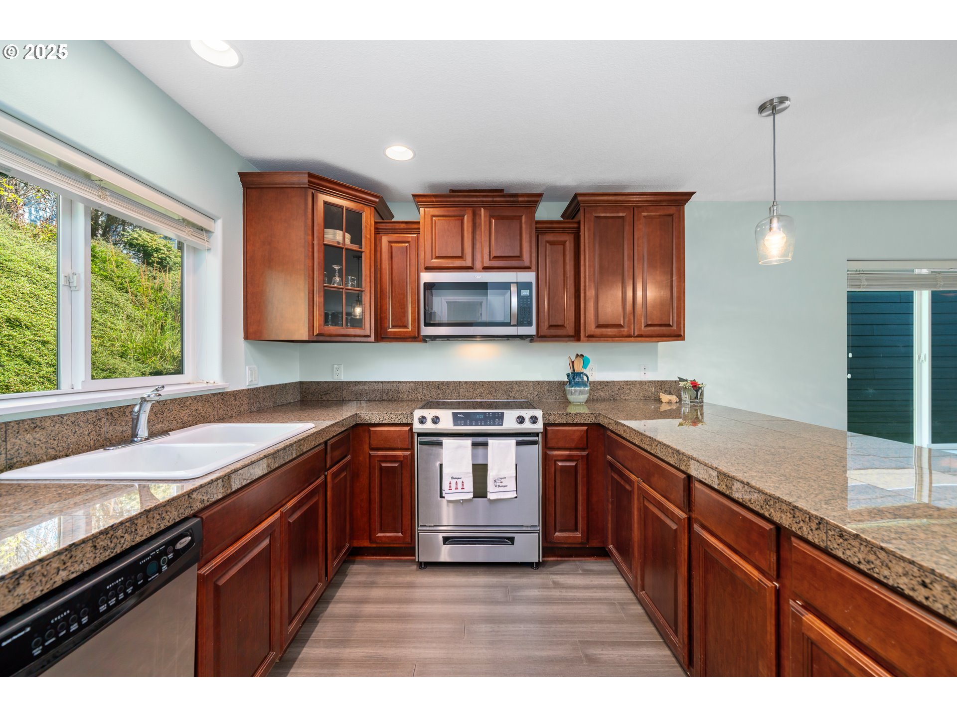 13150 D Street, Unit 12 Nehalem, OR 97131 - Photo 13 of 40 a kitchen with stainless steel appliances granite countertop wooden cabinets a stove top oven a sink and dishwasher next to a window