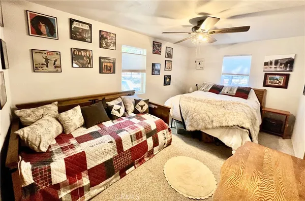 a bedroom with two beds and painting on the wall