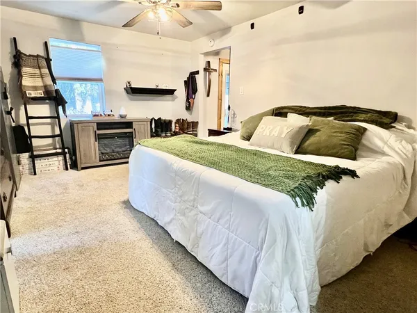 a spacious bedroom with a bed and a television