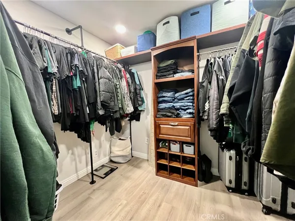 a view of walk in closet with clothes and shoes