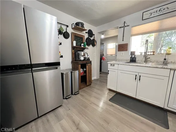 a kitchen with stainless steel appliances a refrigerator sink and wooden floor