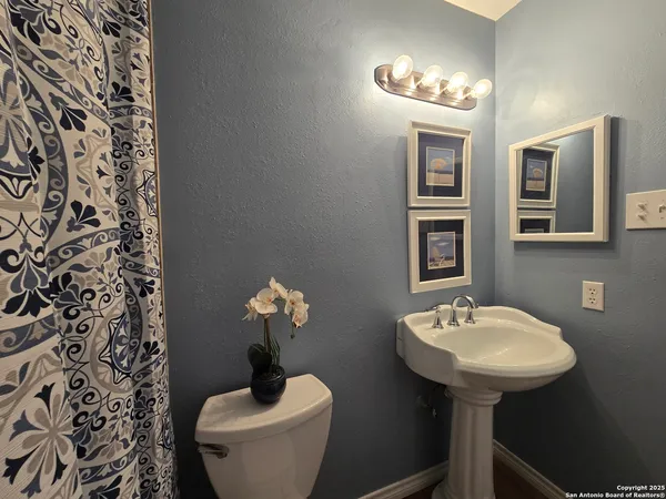 a bathroom with a sink toilet and a mirror