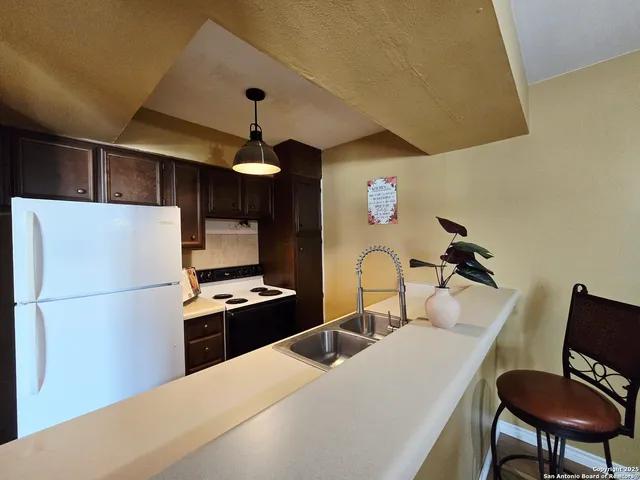 a kitchen with stainless steel appliances a refrigerator and a stove top oven