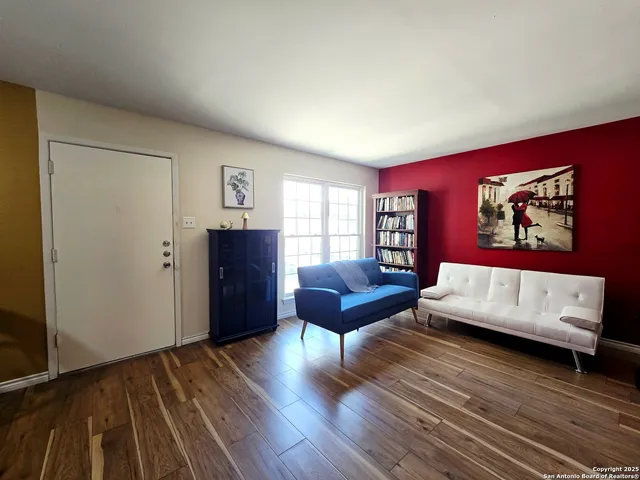 a living room with furniture and a wooden floor