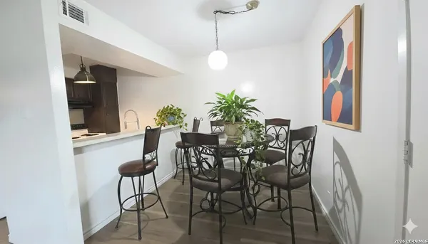 a view of a dining room with furniture and a potted plant