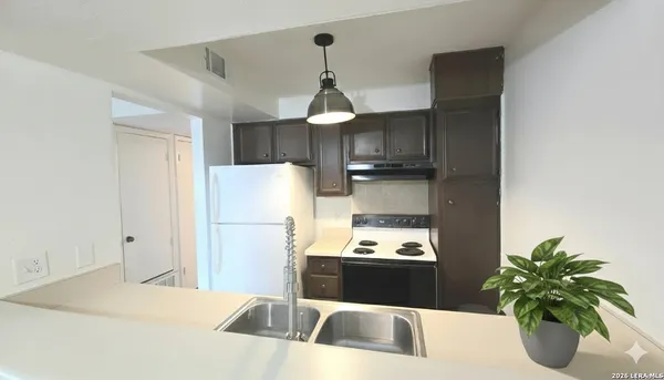 a kitchen with a refrigerator and a sink