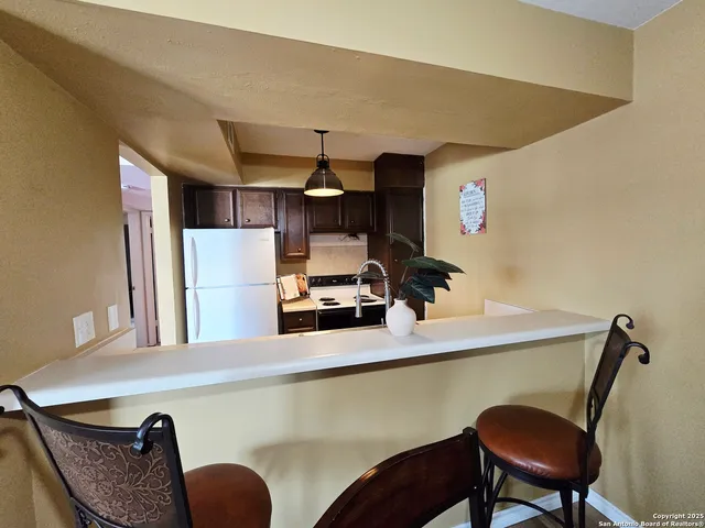 a kitchen with a table chairs and a refrigerator