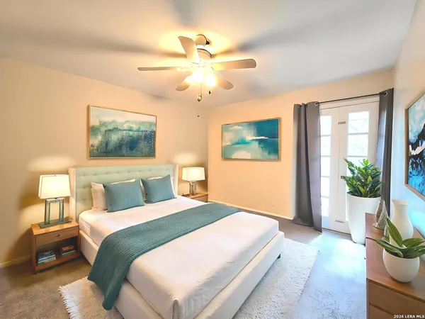 a bedroom with a large bed and a chandelier