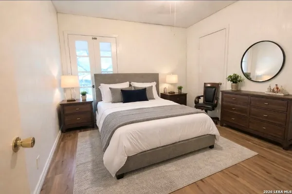 a bedroom with a bed a mirror on dresser and a table