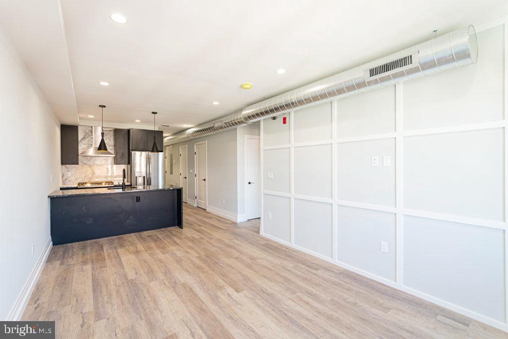 526 Brown Street, Unit 403 Philadelphia, PA 19123 - Photo 2 of 13 a large kitchen with kitchen island a sink stainless steel appliances and cabinets