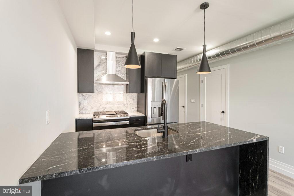 526 Brown Street, Unit 403 Philadelphia, PA 19123 - Photo 3 of 13 a kitchen with kitchen island a counter top space a sink and appliances