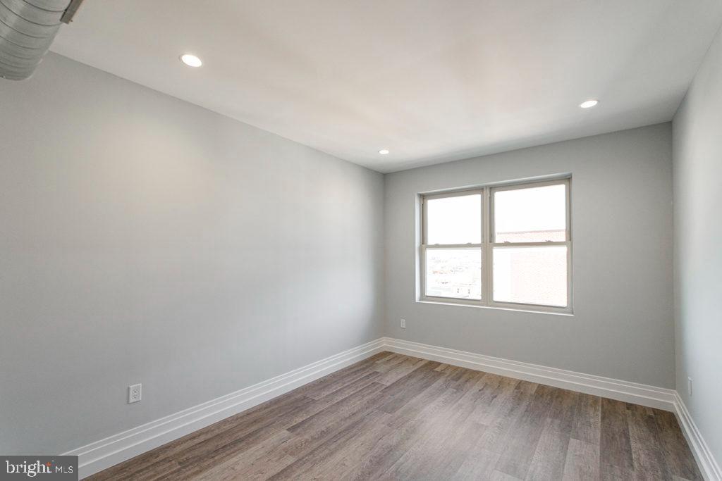 526 Brown Street, Unit 403 Philadelphia, PA 19123 - Photo 7 of 13 an empty room with wooden floor and windows