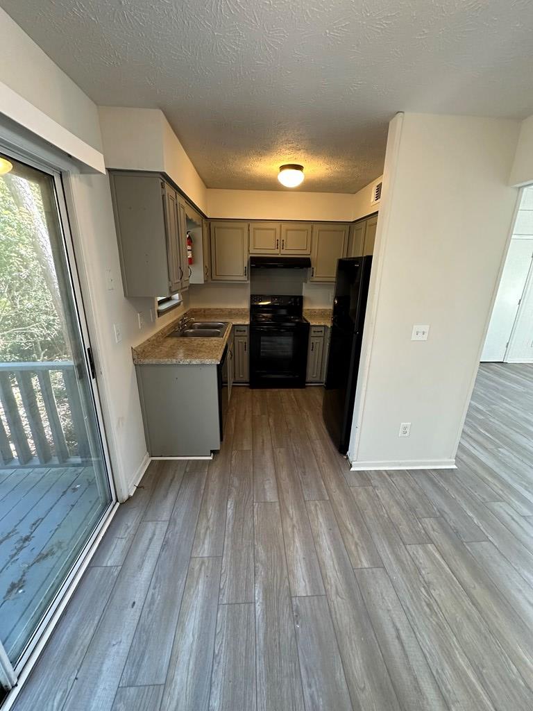 6908 Bullet Boulevard, Unit 7 Columbus, GA 31907 - Photo 2 of 9 a view of a kitchen with wooden floor and electronic appliances