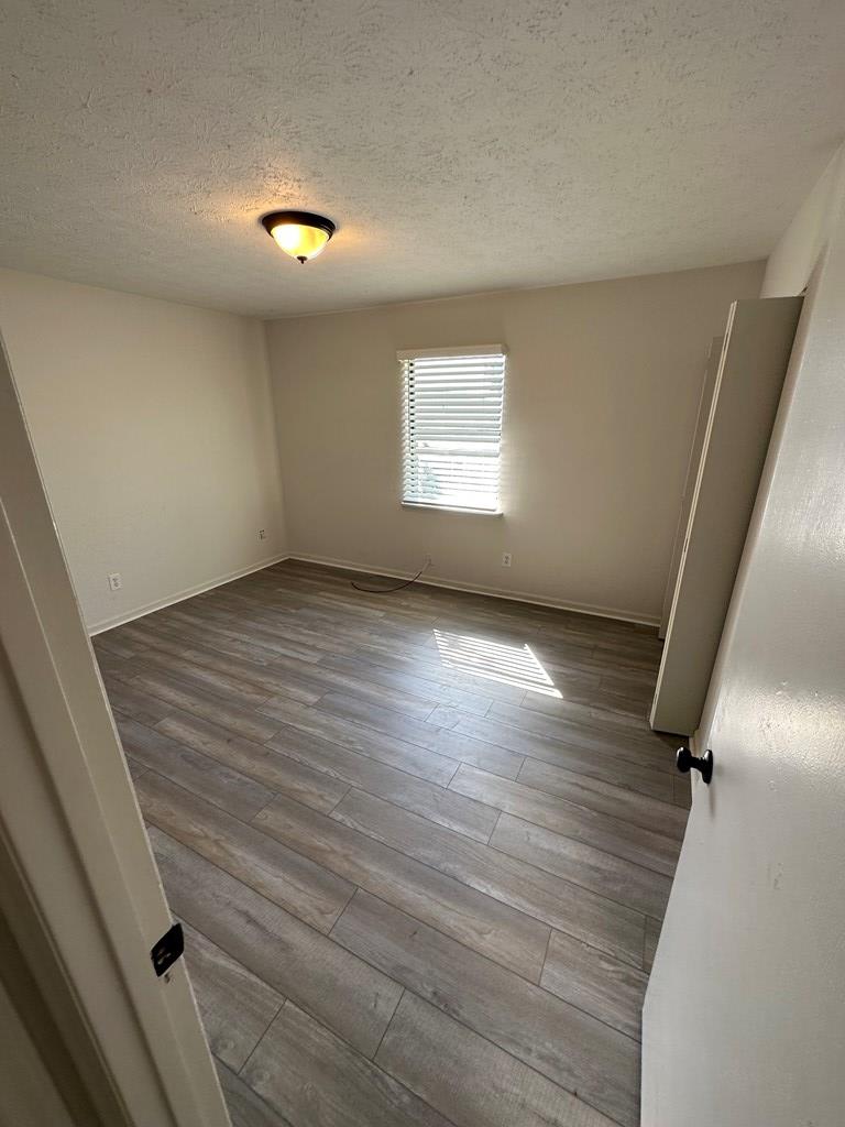 6908 Bullet Boulevard, Unit 7 Columbus, GA 31907 - Photo 4 of 9 wooden floor in an empty room with a window