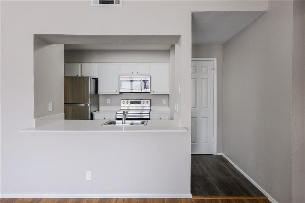 807 West 25th Street, Unit 206 Austin, TX 78705 - Photo 2 of 7 a view of a kitchen with refrigerator and microwave