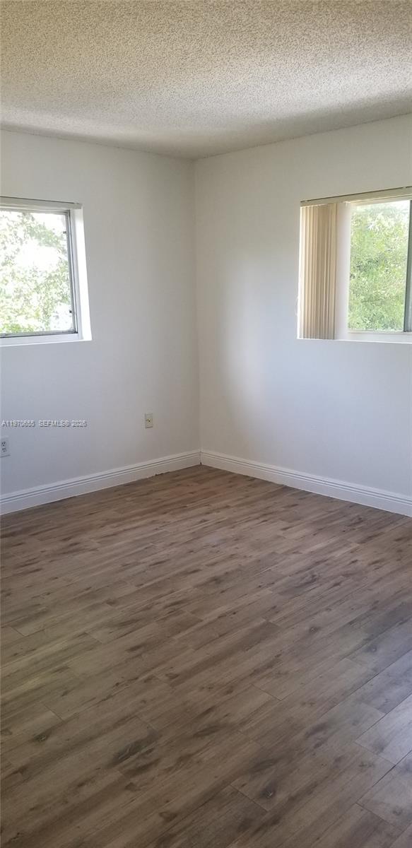 8250 Southwest 149th Court, Unit 8210 Miami, FL 33193 - Photo 19 of 23 a view of an empty room with wooden floor and a window