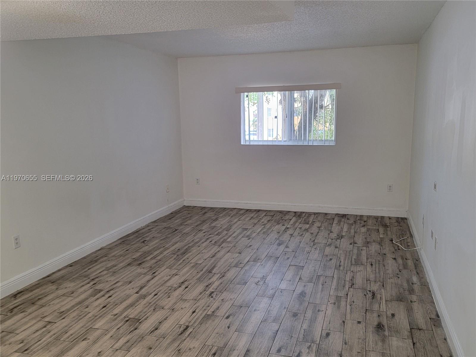 8250 Southwest 149th Court, Unit 8210 Miami, FL 33193 - Photo 5 of 23 a view of a room that has wooden floor and windows in it