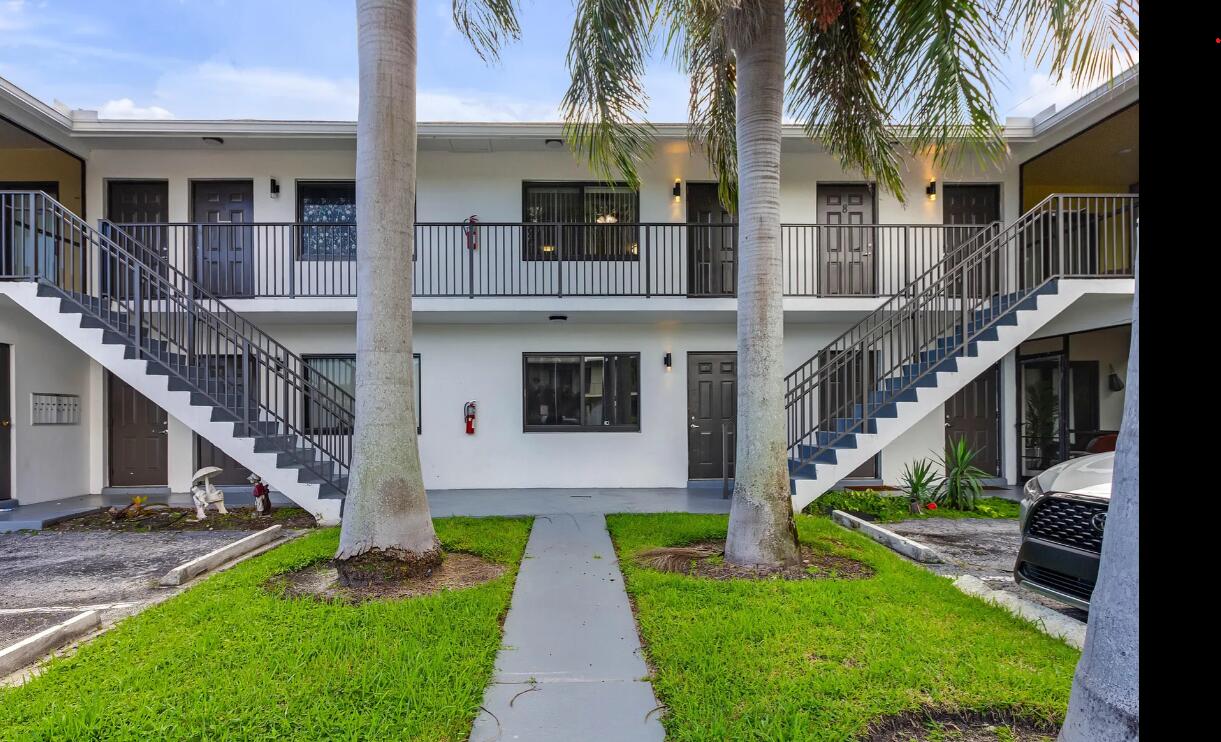 520 Northeast 44th Street, Unit 6 Boca Raton, FL 33431 - Photo 2 of 6 a front view of a house with a yard