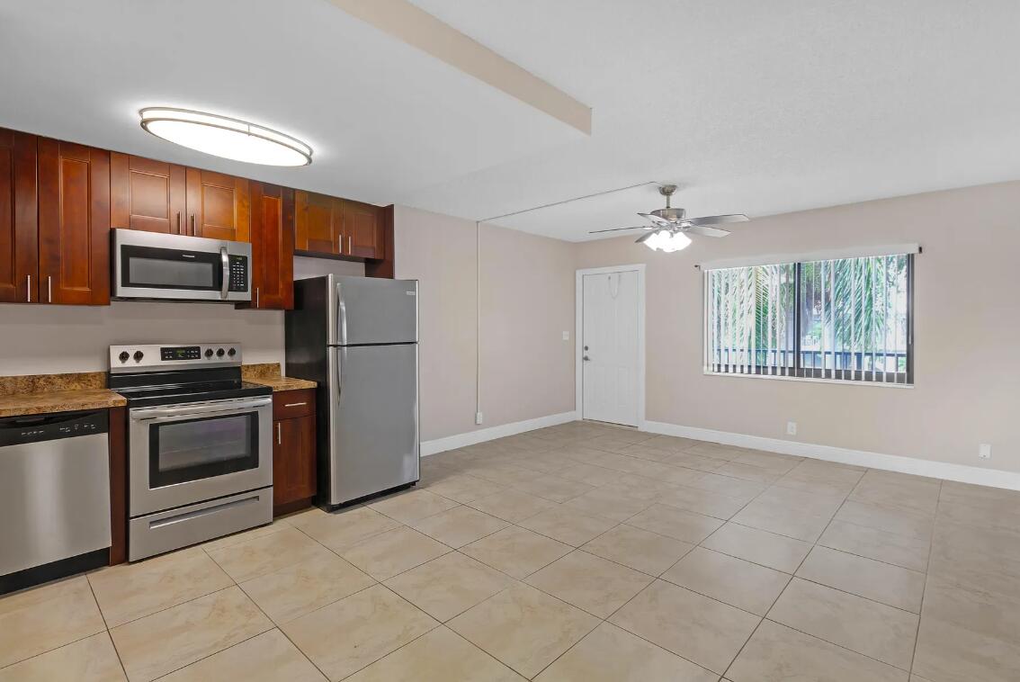 520 Northeast 44th Street, Unit 6 Boca Raton, FL 33431 - Photo 6 of 6 a kitchen with kitchen island granite countertop a stove top oven a sink and a refrigerator