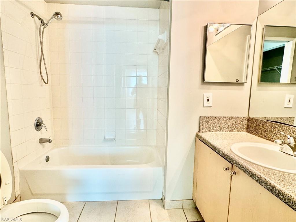 1200 Reserve Way, Unit 103 Naples, FL 34105 - Photo 12 of 26 a bathroom with a granite countertop sink and a mirror