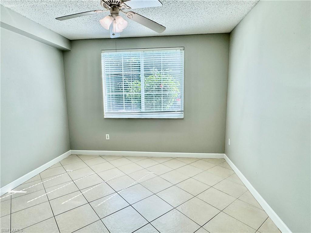 1200 Reserve Way, Unit 103 Naples, FL 34105 - Photo 13 of 26 an empty room with a chandelier fan
