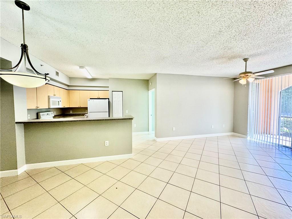 1200 Reserve Way, Unit 103 Naples, FL 34105 - Photo 14 of 26 a view of a room with a wooden floor and a window