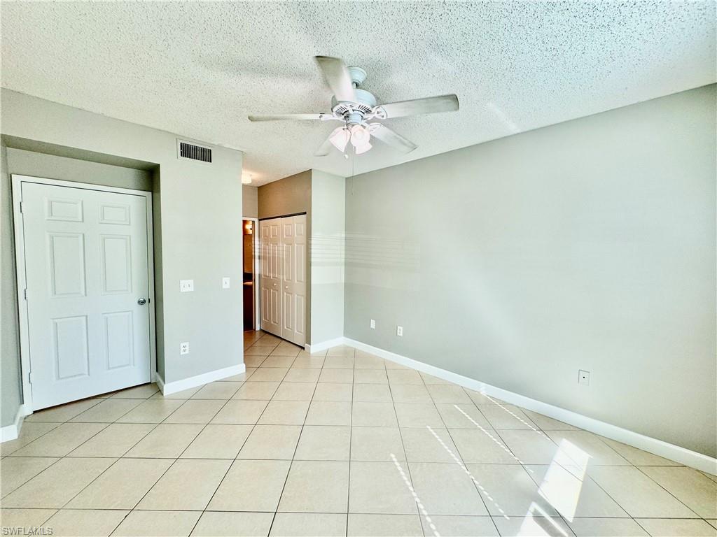 1200 Reserve Way, Unit 103 Naples, FL 34105 - Photo 16 of 26 an empty room with a ceiling fan and carpet