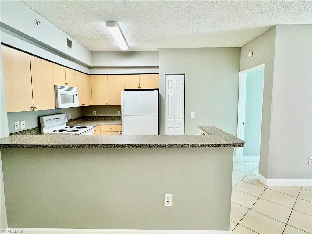 1200 Reserve Way, Unit 103 Naples, FL 34105 - Photo 4 of 26 a view of a kitchen with sink and microwave