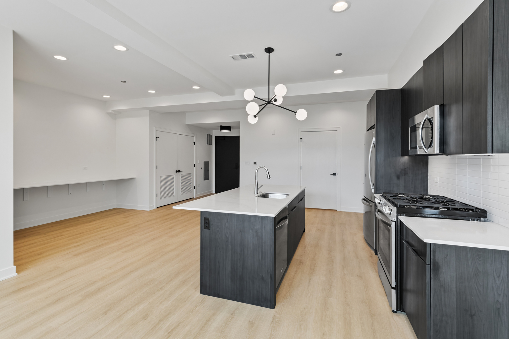 1801 West Grand Avenue, Unit 202 Chicago, IL 60622 - Photo 3 of 16 a kitchen with a stove and a wooden floor