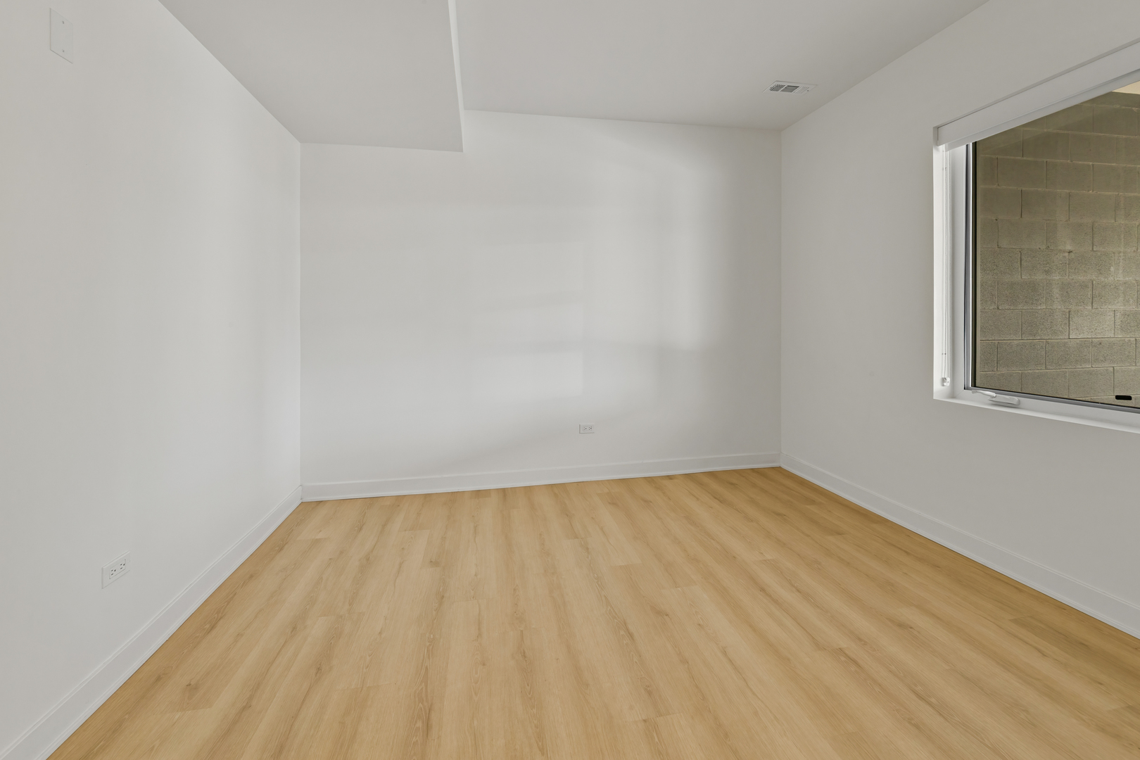 1801 West Grand Avenue, Unit 202 Chicago, IL 60622 - Photo 7 of 16 a view of an empty room with wooden floor and a window