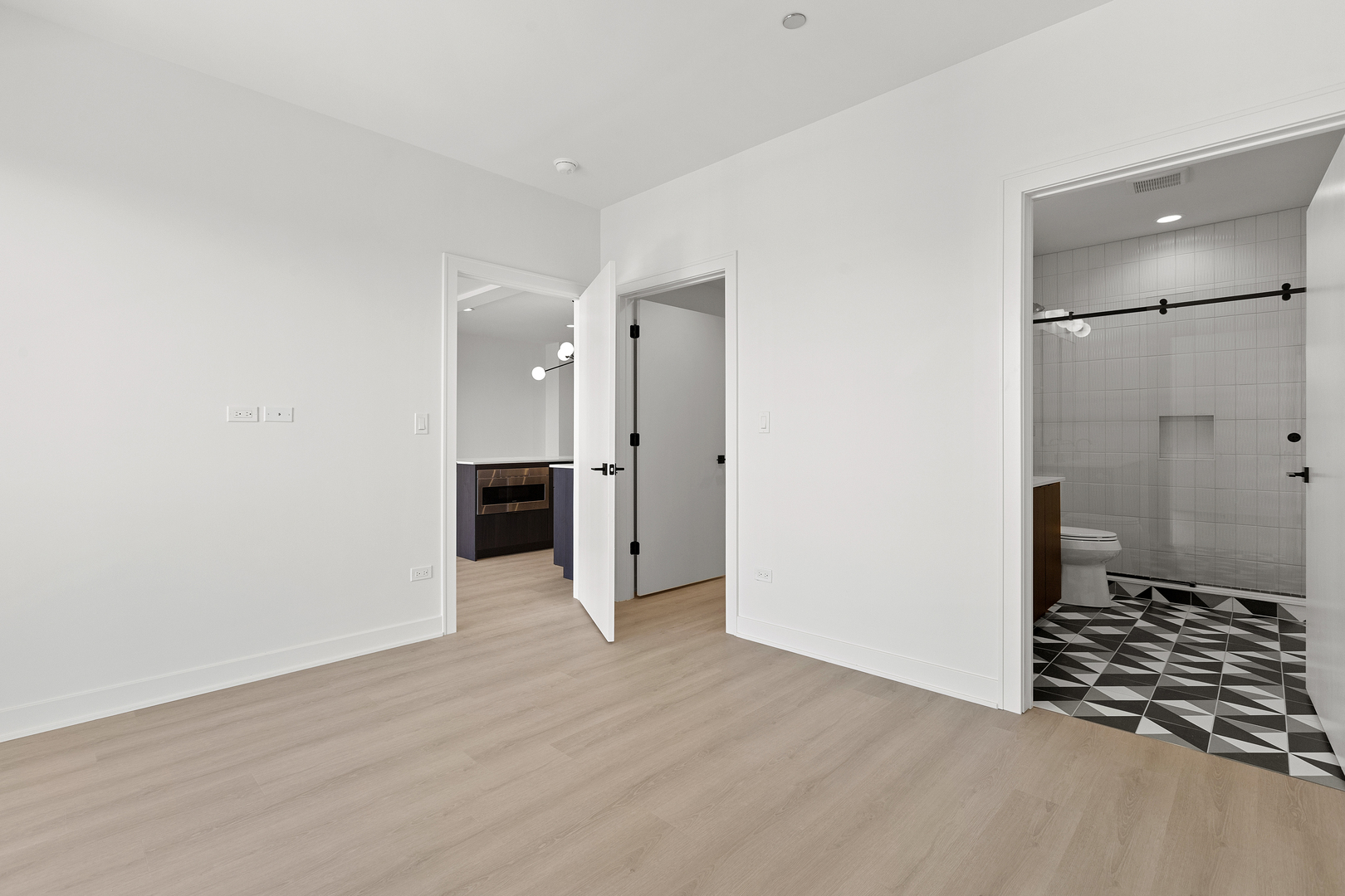 1801 West Grand Avenue, Unit 202 Chicago, IL 60622 - Photo 8 of 16 a view of an empty room with wooden floor and a kitchen