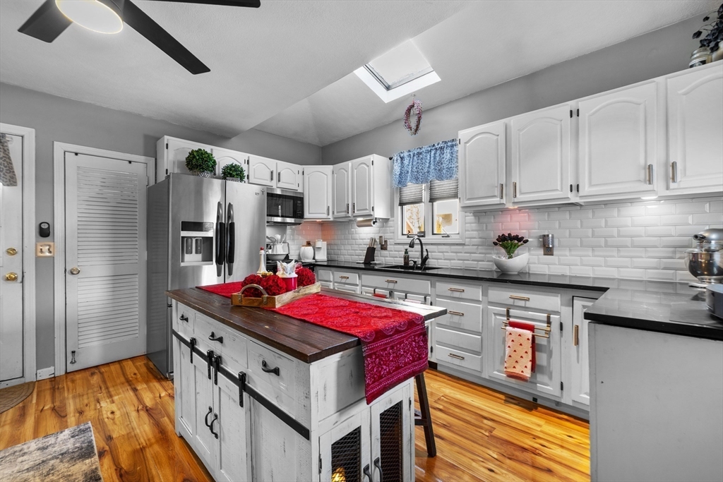 7 Adams Avenue Saugus, MA 01906 - Photo 6 of 38 a kitchen with stainless steel appliances granite countertop a sink stove refrigerator and cabinets