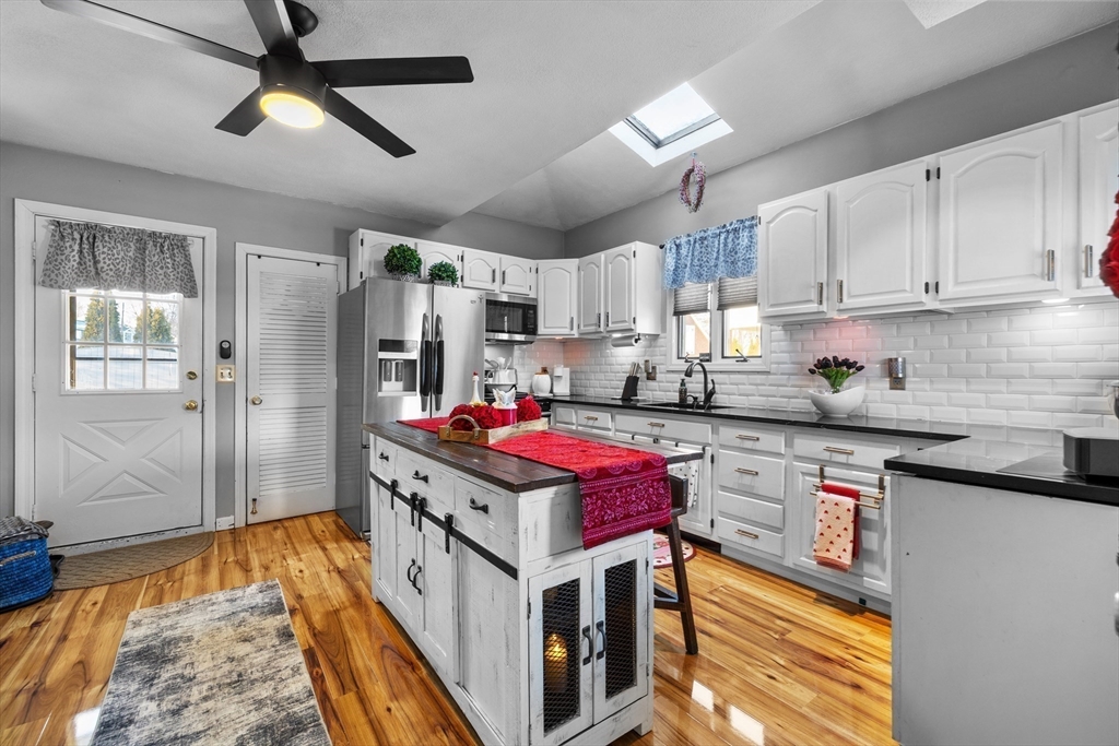 7 Adams Avenue Saugus, MA 01906 - Photo 8 of 38 a kitchen with stainless steel appliances granite countertop a stove refrigerator and cabinets