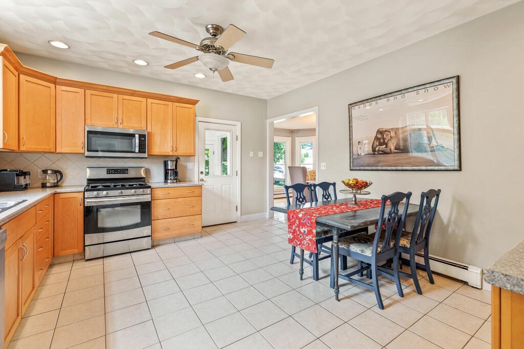 45 Spring Street Stoneham, MA 02180 - Photo 11 of 30 a kitchen with stainless steel appliances kitchen island granite countertop a sink cabinets and a dining table