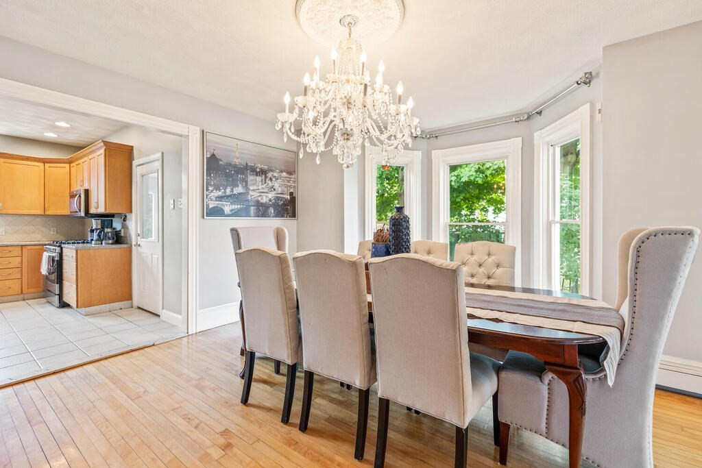45 Spring Street Stoneham, MA 02180 - Photo 9 of 30 a dining room with furniture a chandelier and wooden floor