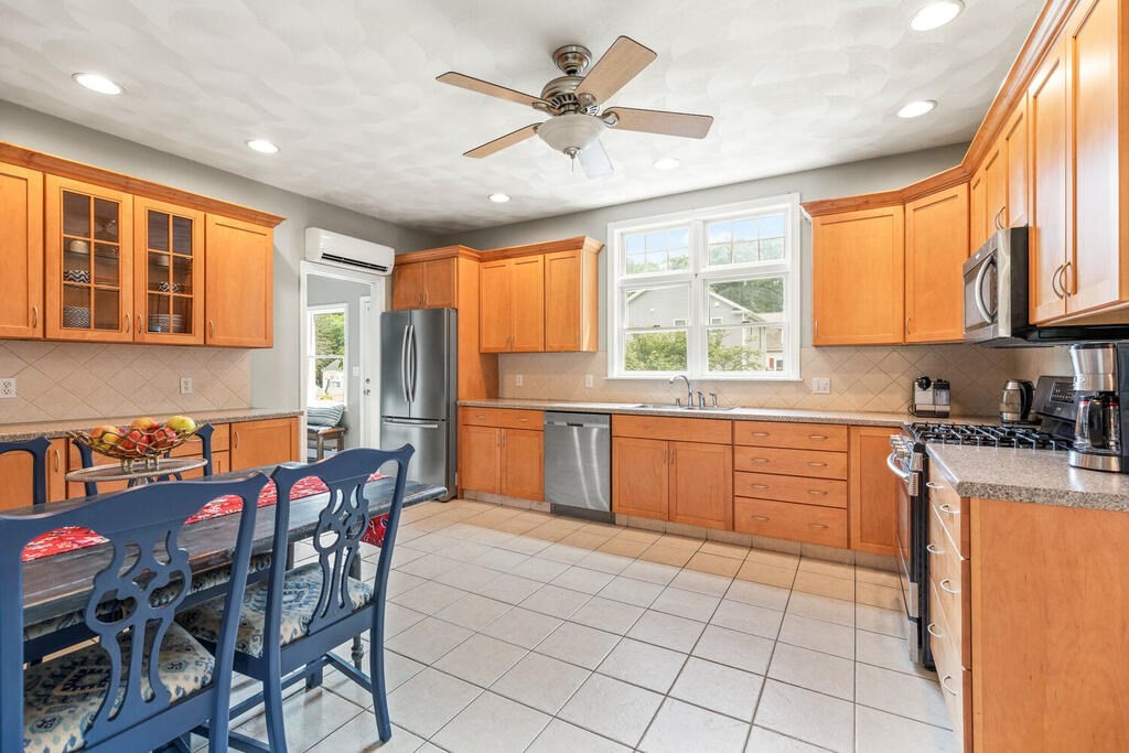 45 Spring Street Stoneham, MA 02180 - Photo 10 of 30 a kitchen with a sink a counter top space appliances and a window
