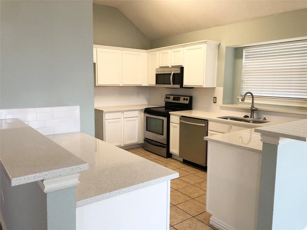 10350 Hampton Court Frisco, TX 75035 - Photo 12 of 27 a kitchen with stainless steel appliances a sink stove refrigerator and white cabinets
