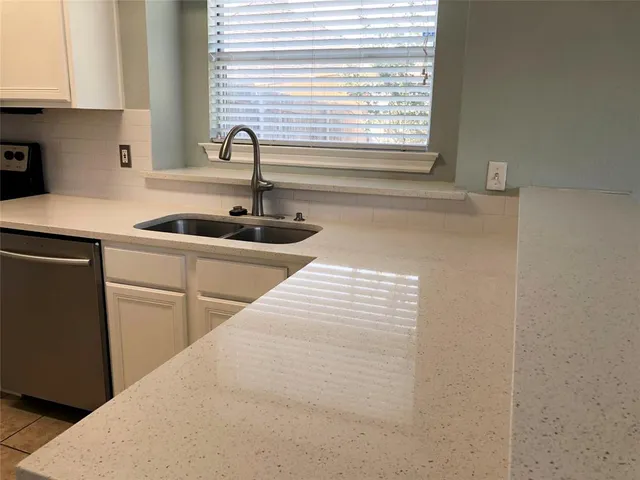 a kitchen with a sink and wooden floor