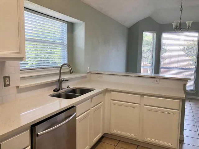 a kitchen with a sink and wooden floor