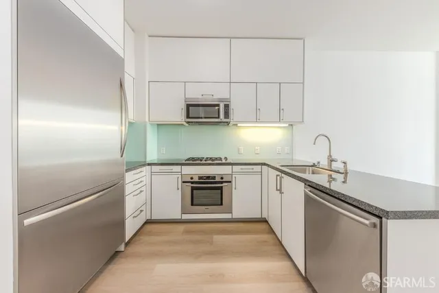 a kitchen with stainless steel appliances granite countertop a refrigerator sink and stove