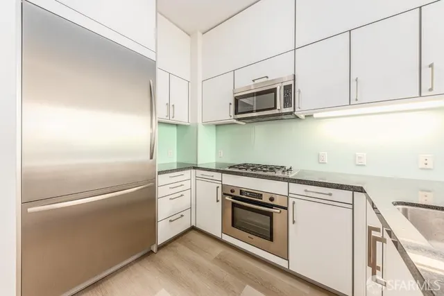a kitchen with stainless steel appliances white cabinets and a stove