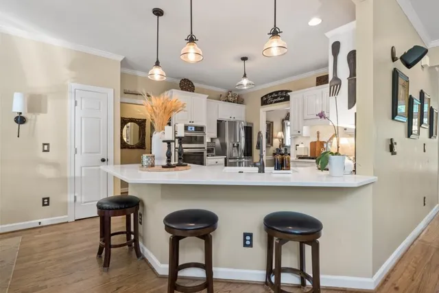 a living room with furniture kitchen view and a chandelier