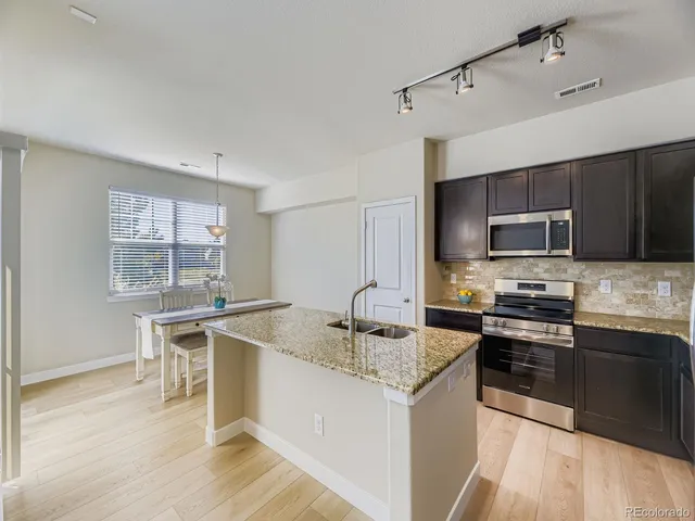 a kitchen with stainless steel appliances granite countertop a sink stove and microwave