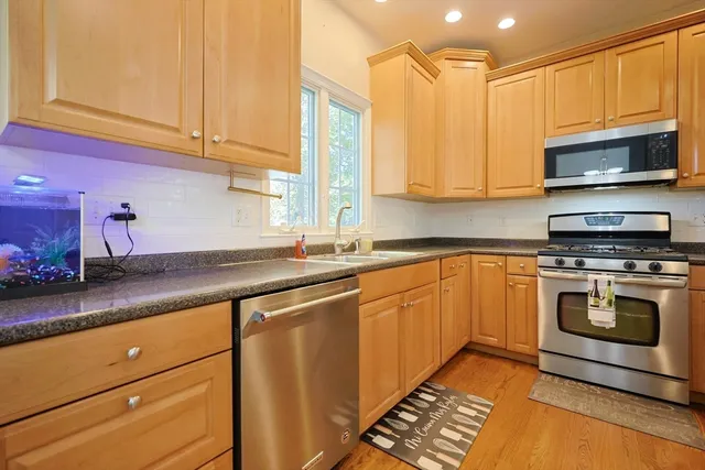 a kitchen with stainless steel appliances granite countertop a sink a stove and a microwave